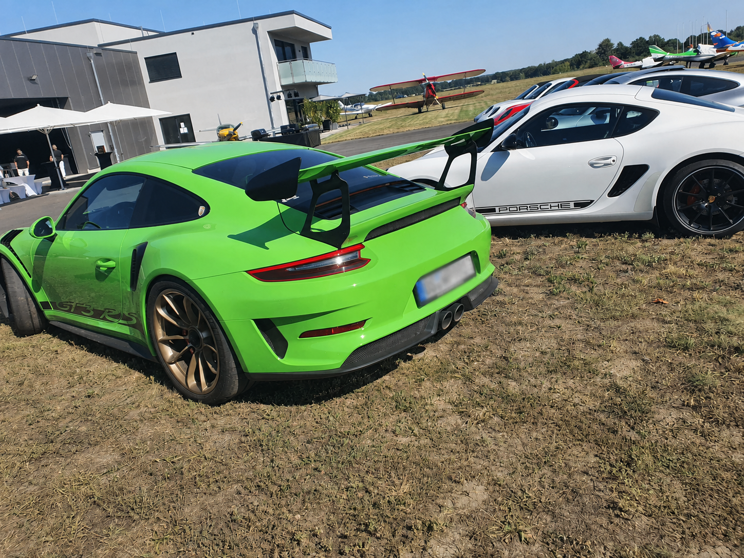 Porsche auf dem Flugplatz Kamenz Grüner Porsche 911 GT3 RS neben weiteren Porsche-Fahrzeugen auf dem Flugplatz Kamenz