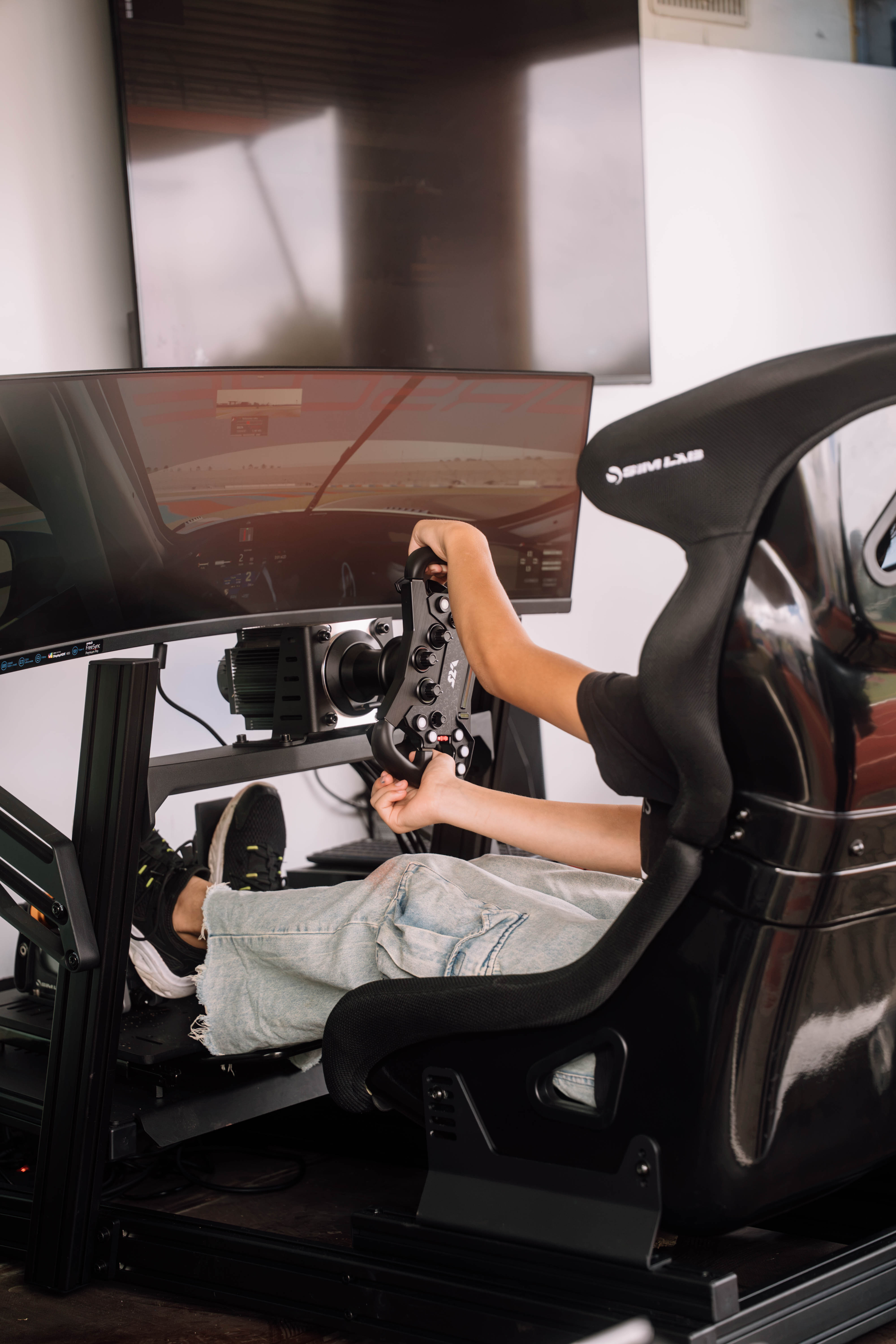 Simracing im mobilen Simshuttle Junge Person fährt im Rennsimulator des Simshuttles der RacingLounge77